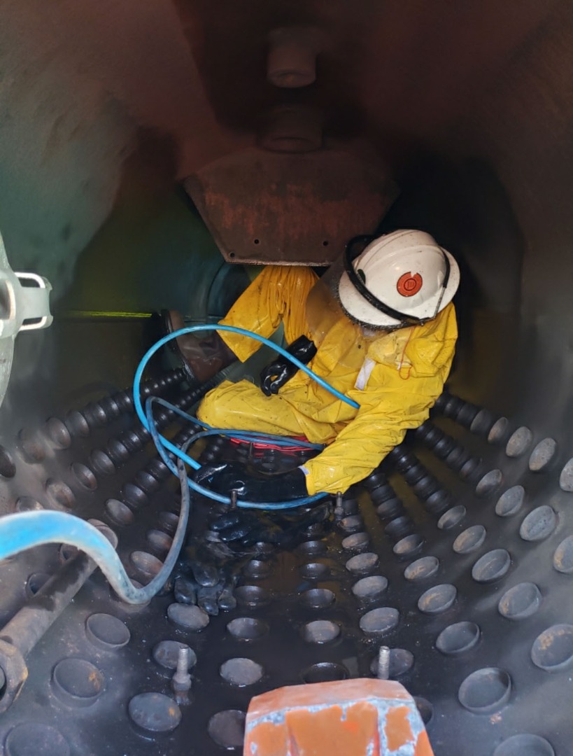 CleanCo Systems worker cleaning  2" tubes inside a boiler